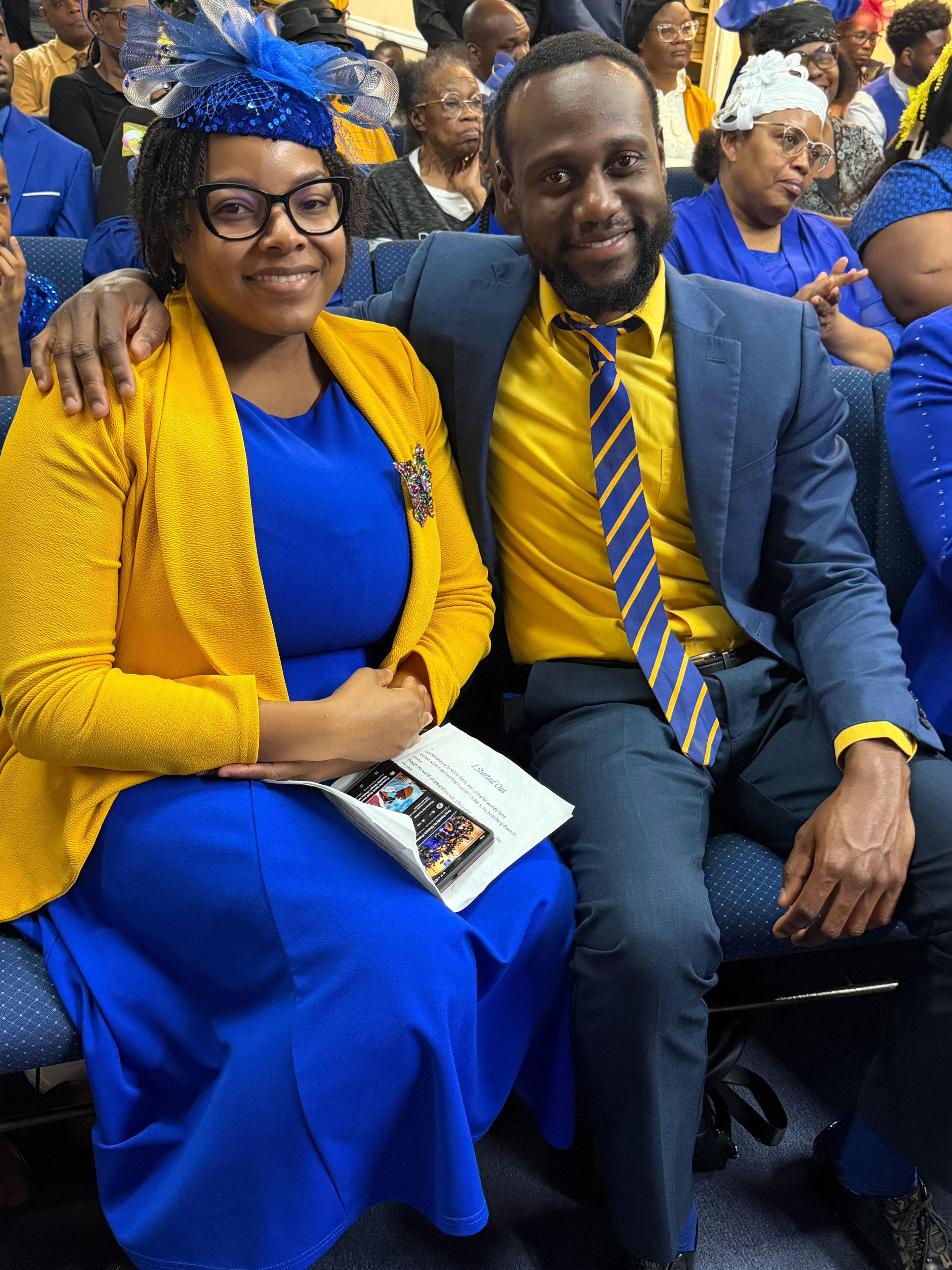 Church members in blue and yellow attire seated at a service